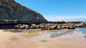 walking across a rocky ledge at Twin Reefs Bunarong Coastal Reserve Inverloch