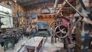 an assortment of historic pieces such as horse cart in a shed