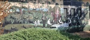 wall art showing pioneers in the forest sitting down at a table with white linen