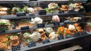 a display cabinet of delicious looking sandwiches and pastries