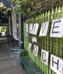 a sign on a fence displaying the store olive at lcoh