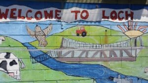 a colourful painted sign of loch village