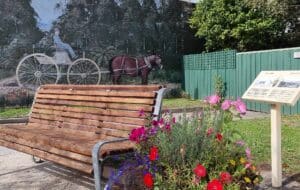 mural showing old fashioned horse drawn cart with bench seat and flower pot out front