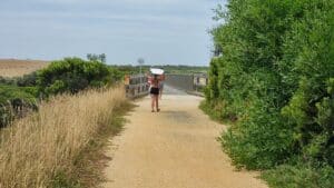 girl with surfboard over her head walking along the bass Coast Rail Trail Kilcinda