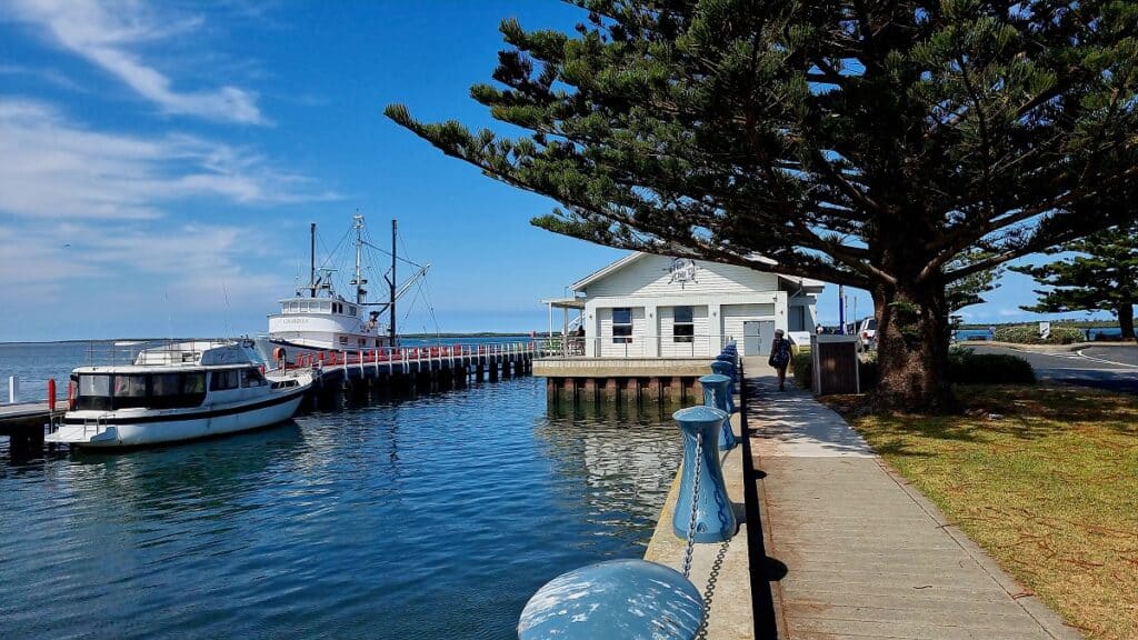 the fish and chip store sits on the jetty at Port Albert with boasts out front - things to do in Gippsland